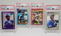 Four Lot Of 4 PSA 8 Ken Griffey Jr. Rookies - 1989 Donruss, 1989 Fleer, 1990 Toys R Us, and 1990 Topps baseball cards are displayed in a display case.